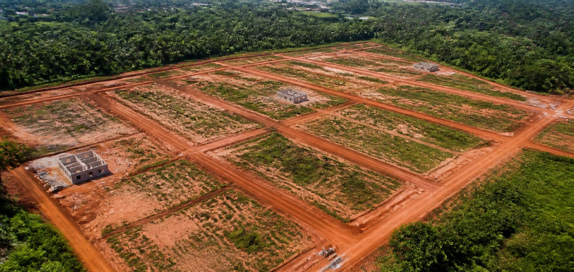 Vue aérienne d'un lotissement avec parcelles préparées et voies d'accès.